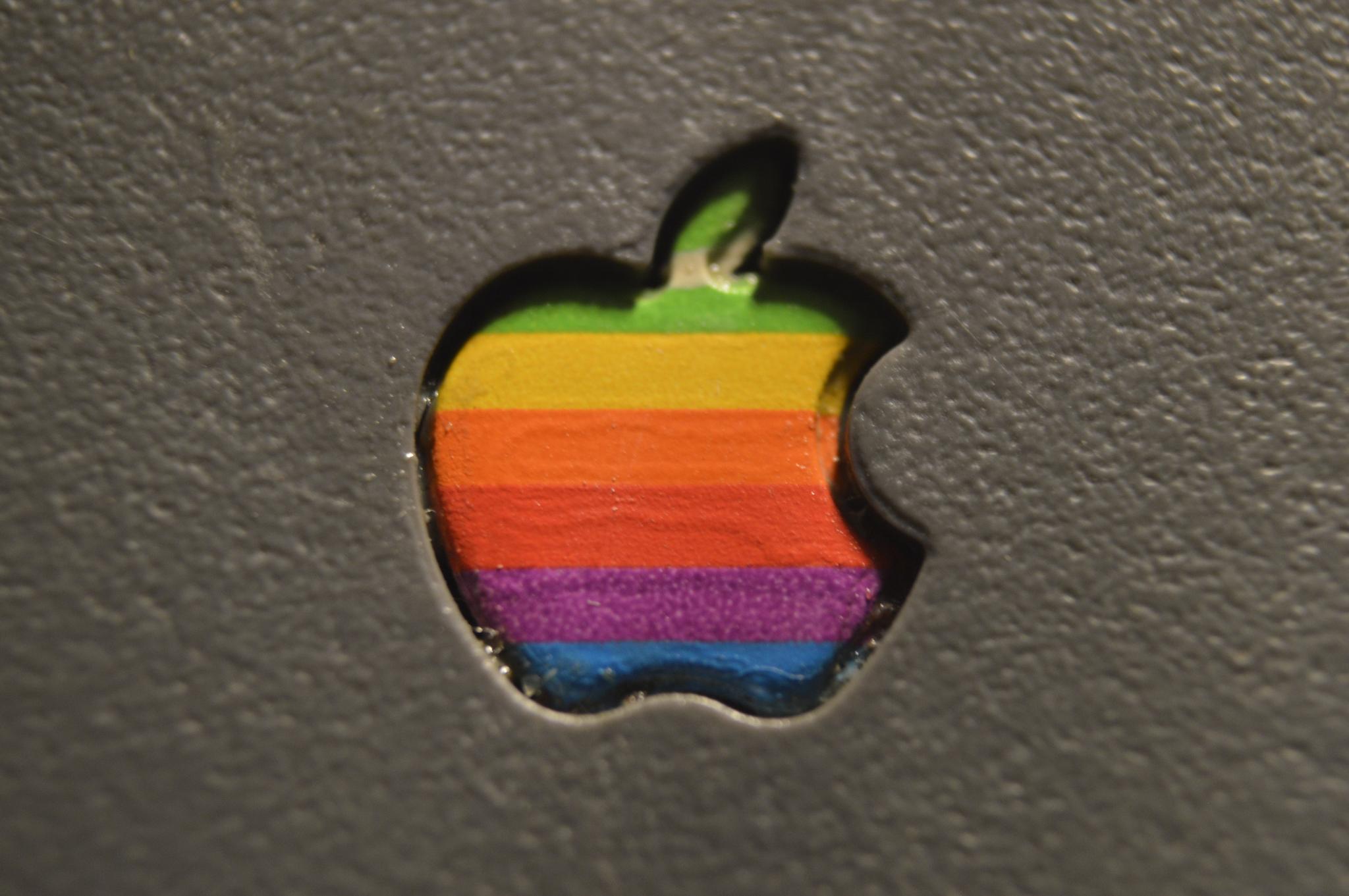 a closeup photo of the lid of a powerbook 165c. a rainbow apple computer logo is surrounded by the textured grey plastic