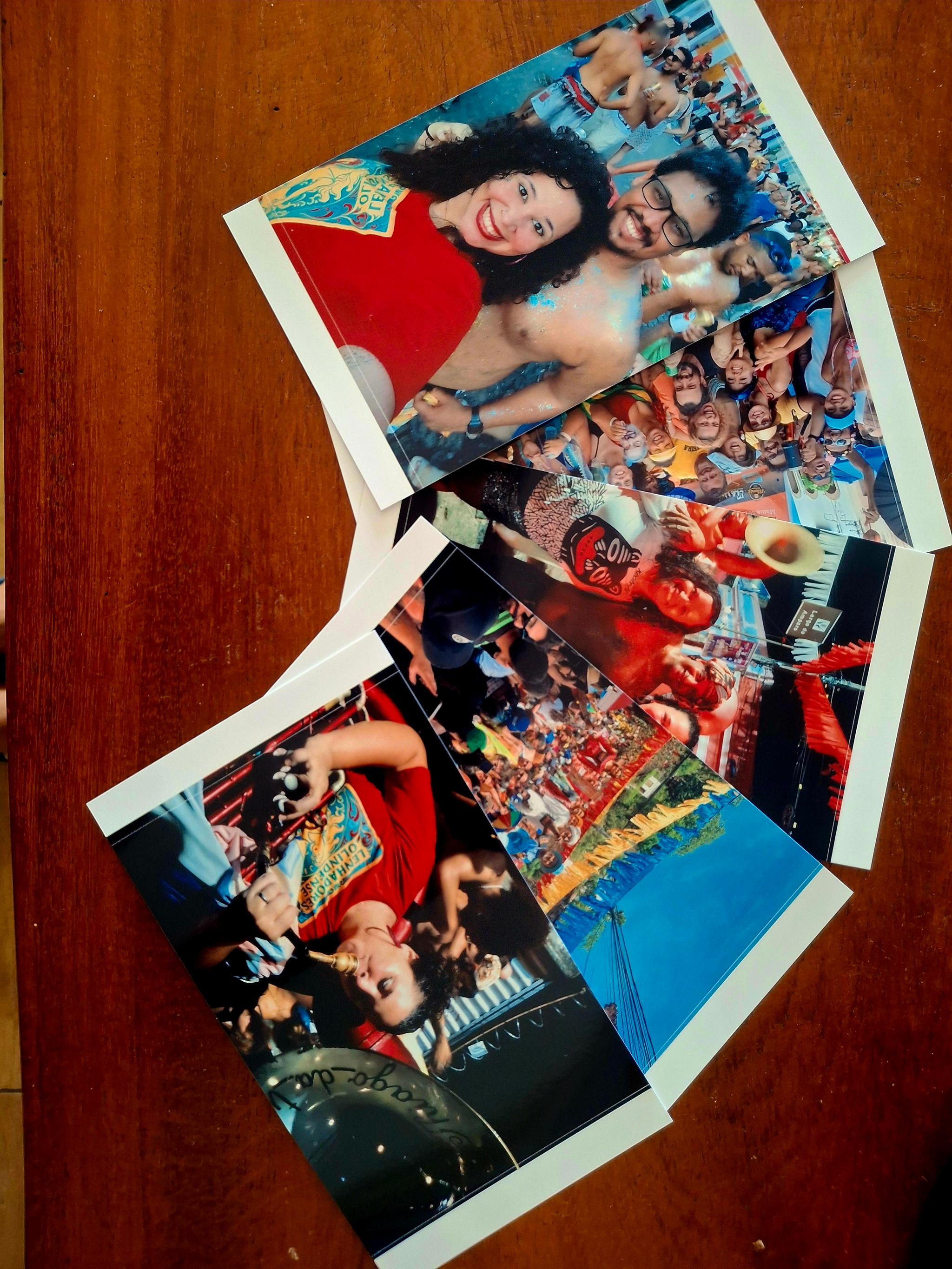 Foto de uma série de fotos impressas postas sob uma mesa de madeira