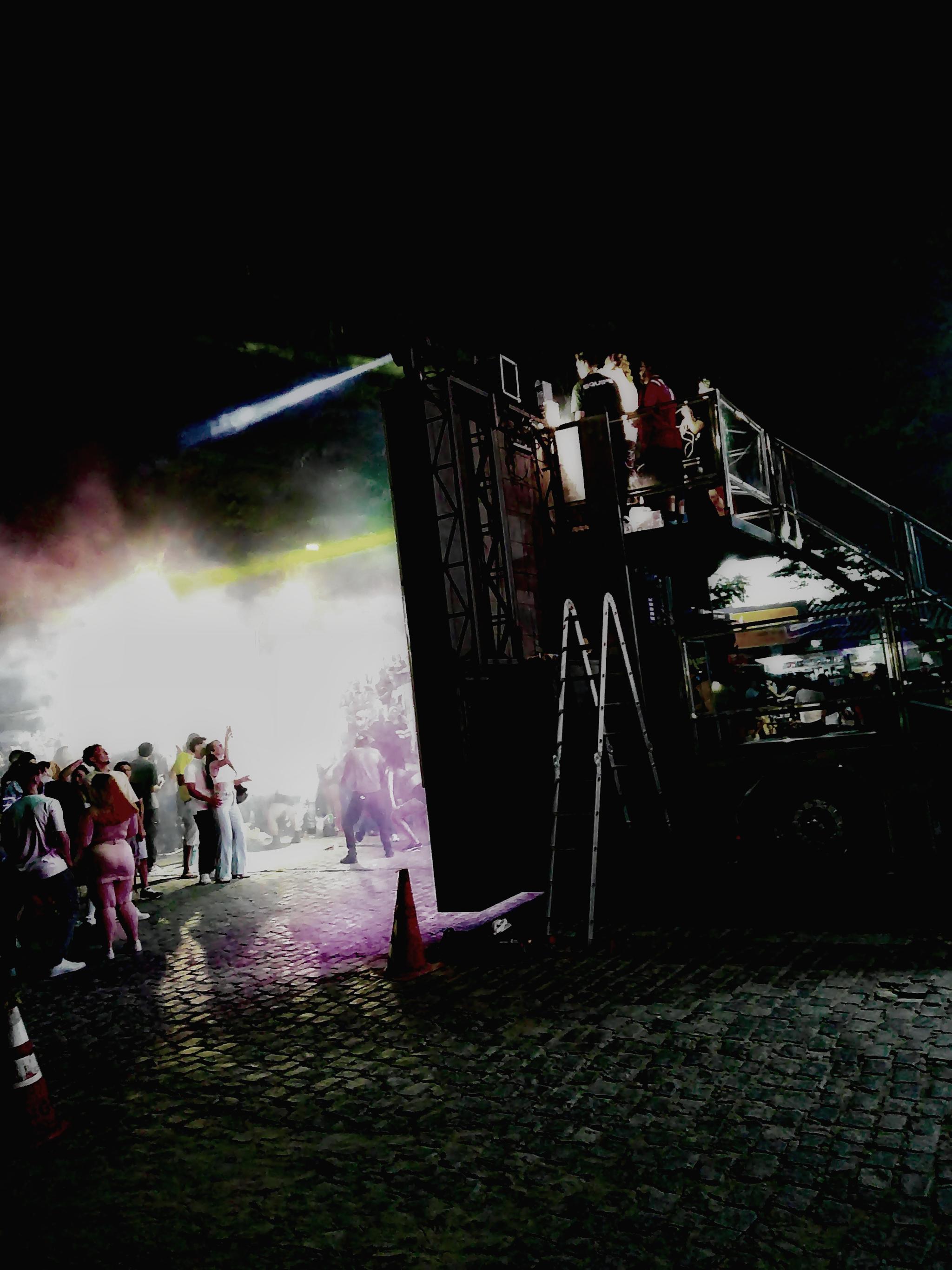 Lateral de um palco com pessoas dançando no