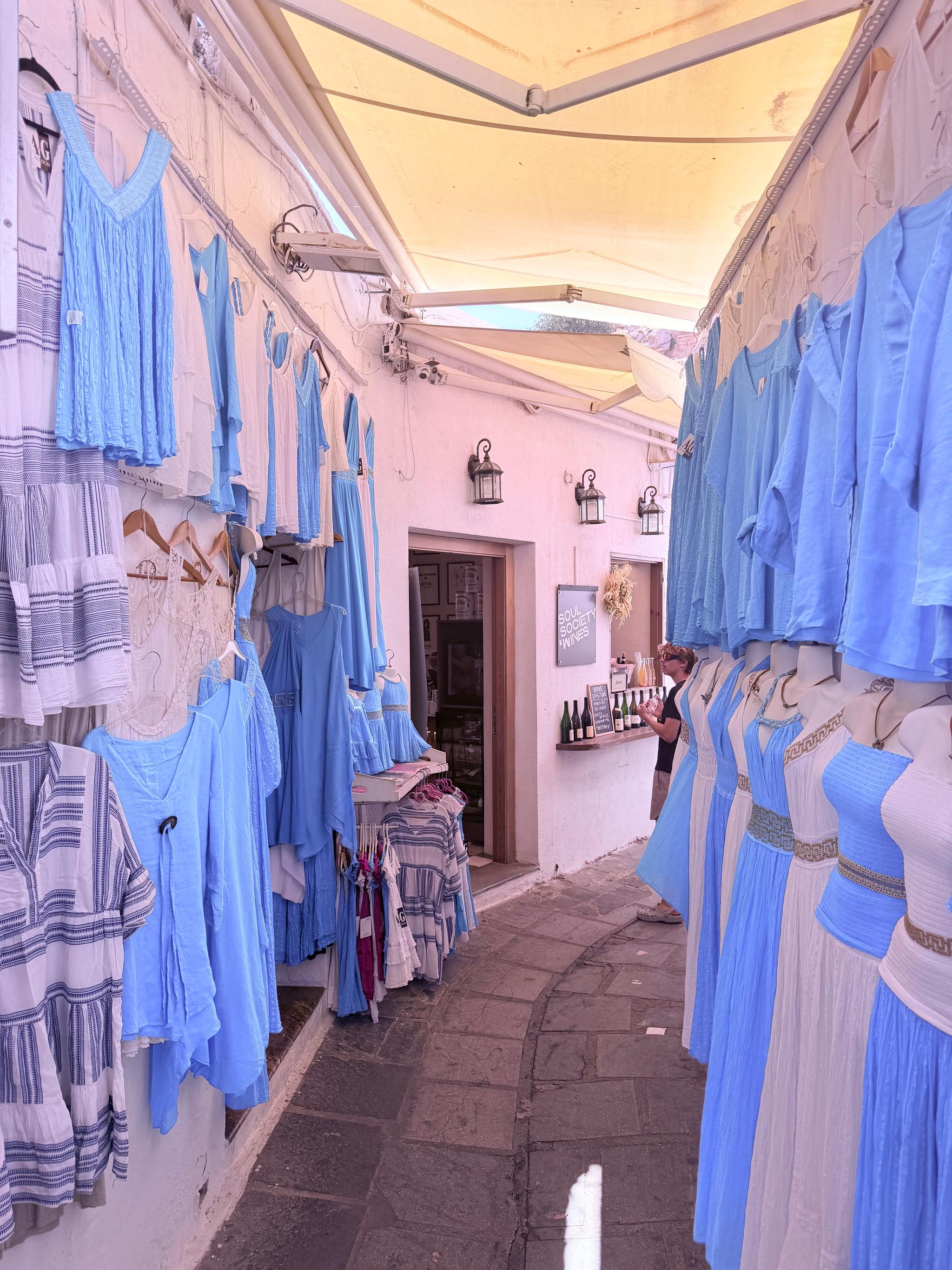 blue and white clothing hangs in an alley