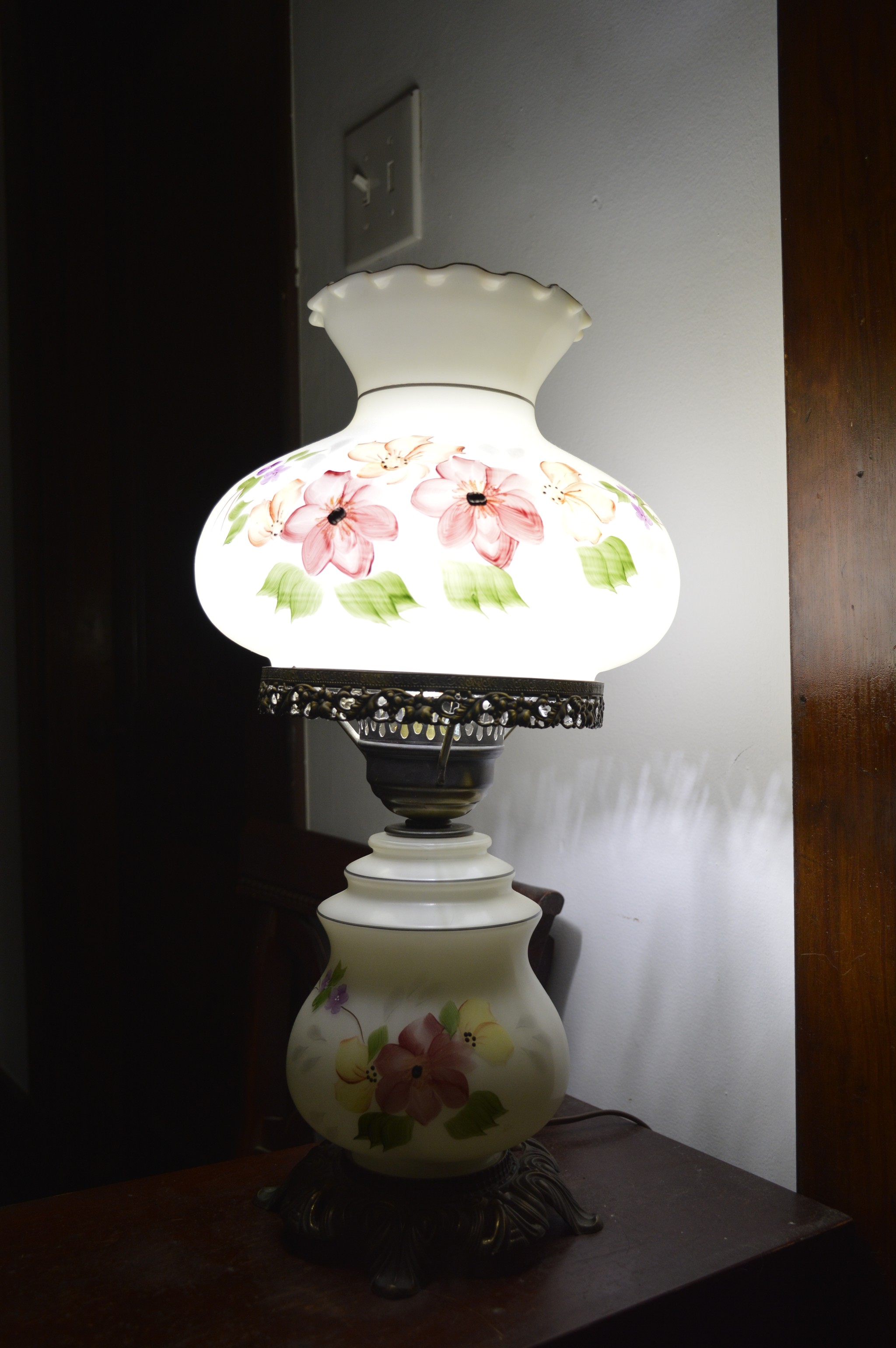 a glass lamp with floral painting on it